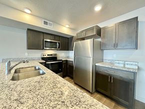 Millcreek apartment for rent - a kitchen with stainless steel appliances and granite counter tops