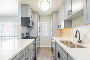 Santa Monica apartment for rent - A kitchen with a white counter top and grey cabinets.
