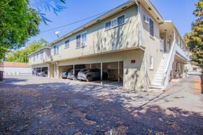Valley Village apartment for rent - A two-story building with a parking lot in front.