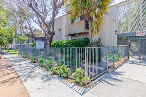 Valley Village apartment for rent - a yard with a fence and plants in front of a building
