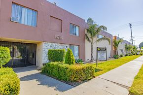 Northridge apartment for rent - a pink building with a sign on it and a sidewalk