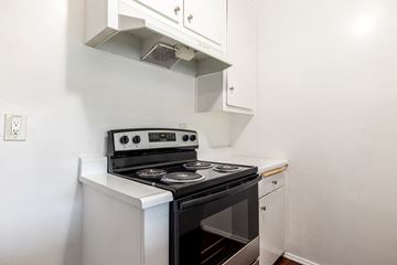 Valley Village apartment for rent - A white stove with a black oven sits under a vent in a kitchen.