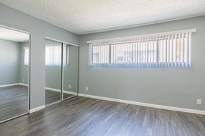 Valley Village apartment for rent - A room with grey walls and wooden flooring with a window covered by a white blind.