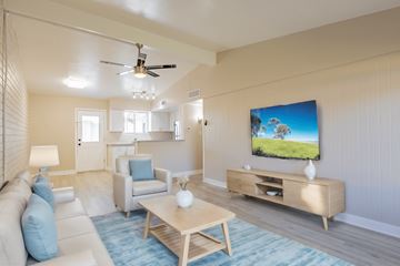 Phoenix apartment for rent - A living room with a television and a white couch.