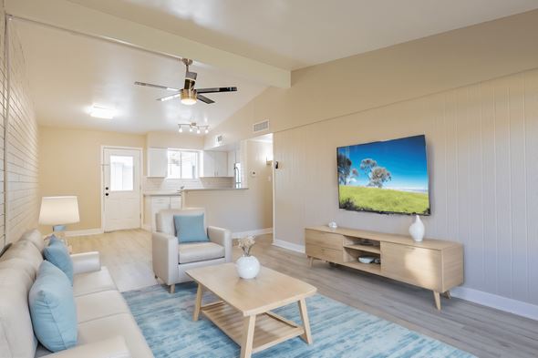 Phoenix apartment for rent - A living room with a television and a white couch.