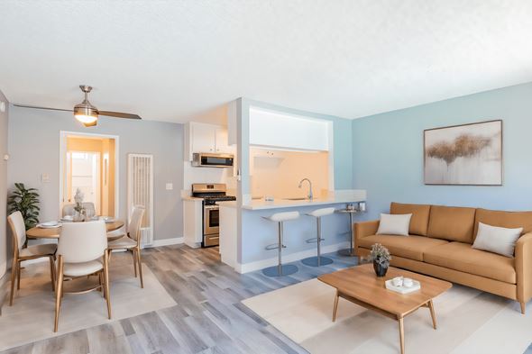Van Nuys apartment for rent - A living room with a brown sofa and a dining table with chairs.