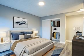 Van Nuys apartment for rent - A bedroom with a large bed and a painting above it.