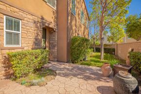 Buena Park apartment for rent - a backyard with a stone building and vases on the ground
