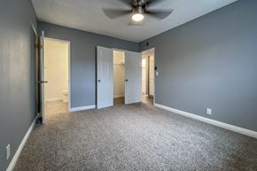 Buena Park apartment for rent - an empty living room with blue walls and a ceiling fan