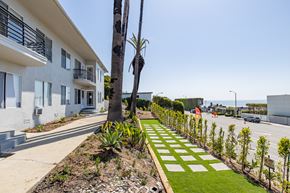 Malibu apartment for rent - A white building with a balcony and a tree in front of it.