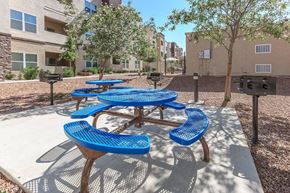 El Paso apartment for rent - an outdoor picnic area with blue picnic tables and benches