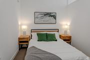 Minneapolis apartment for rent - a bedroom with a bed with green pillows and a painting on the wall