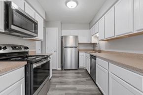 Eagan townhouse for rent - an empty kitchen with white cabinets and stainless steel appliances