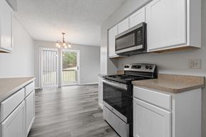 Eagan townhouse for rent - the kitchen of our studio apartment atrium with white cabinets and black appliances