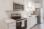 Minneapolis apartment for rent - a kitchen with white cabinets and stainless steel appliances and a microwave