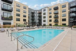Columbia Heights apartment for rent - A swimming pool surrounded by apartment buildings and lounge chairs.