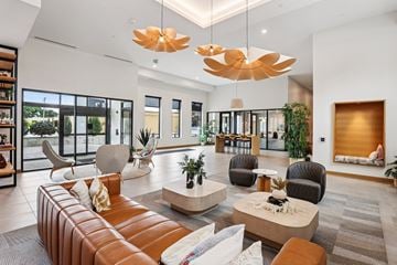 Columbia Heights apartment for rent - A modern living room with a brown leather sofa and a large chandelier.