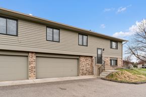 Eagan townhouse for rent - the front of a tan house with a garage door