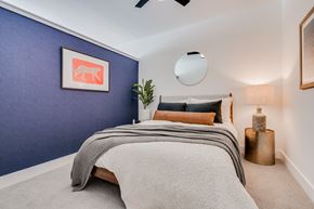 St. Paul apartment for rent - A bedroom with a bed, pillows, a ceiling fan, and a framed picture on the wall.