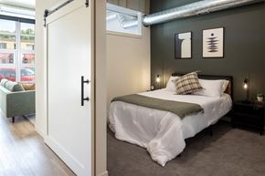 North St. Paul apartment for rent - A bedroom with a white bed and a green chair.