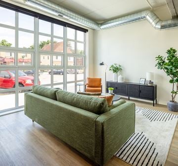 North St. Paul apartment for rent - A living room with a green couch and a large window.