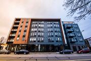 Minneapolis apartment for rent - A modern multi-story apartment building with cars parked in front.