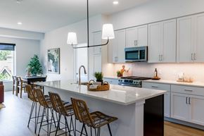 Wayzata apartment for rent - A modern kitchen with white cabinets and a large island.
