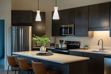 North St. Paul apartment for rent - A kitchen with a refrigerator, microwave, oven, sink, and chairs.