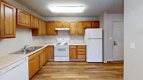 Maplewood apartment for rent - A kitchen with wooden cabinets and white appliances.