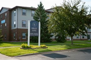 Maplewood apartment for rent - A sign for Sibley Cove, a now leasing apartment complex, stands in front of a brick building.