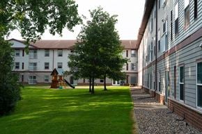 Maplewood apartment for rent - A playground with a slide is in the middle of a grassy area.