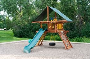 Maplewood apartment for rent - A playground with a green slide and a yellow and brown wooden structure.