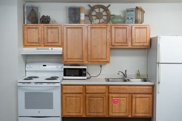 Maplewood apartment for rent - A kitchen with wooden cabinets and a white refrigerator.
