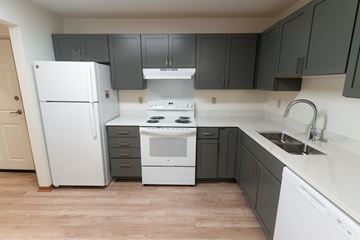 Mounds View apartment for rent - A kitchen with a white refrigerator and a white stove top oven.