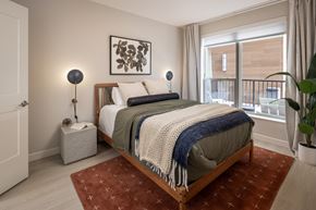 St Paul apartment for rent - A bedroom with a bed, two lamps, and a painting on the wall.