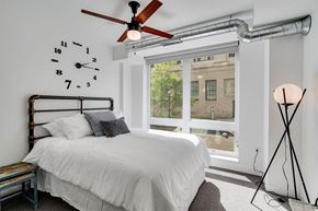 St. Paul apartment for rent - a bedroom with a large window and a bed and a ceiling fan