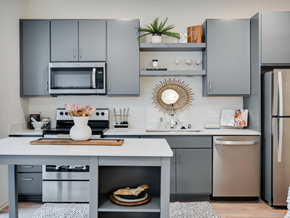 Minneapolis apartment for rent - a kitchen with gray cabinets and stainless steel appliances and a white counter top