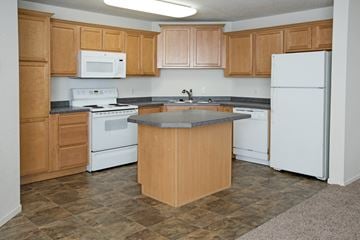 Maplewood townhouse for rent - a kitchen with white appliances and wooden cabinets