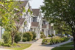 Maplewood townhouse for rent - A white house with a grey roof and a tree in front of it.