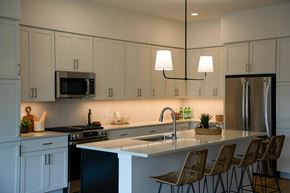 Wayzata apartment for rent - A kitchen with white cabinets and a black stove top oven
