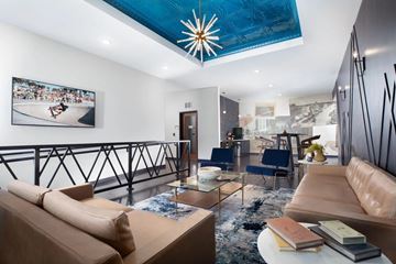 Shakopee apartment for rent - A living room with a tan sofa and a blue ceiling light.