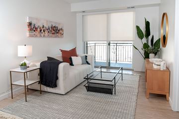 Minneapolis apartment for rent - A living room with a white couch, a coffee table, and a painting on the wall.
