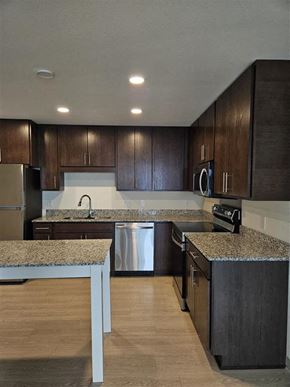 Hopkins apartment for rent - A kitchen with dark wood cabinets and a granite countertop.