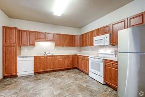 Saint Paul apartment for rent - A kitchen with wooden cabinets and white appliances.
