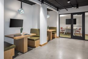 Minneapolis apartment for rent - A modern office space with a TV mounted on the wall and a glass door leading to another room.