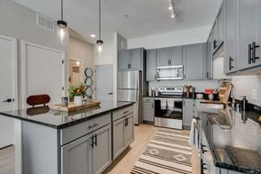 Roseville apartment for rent - a kitchen with stainless steel appliances and gray cabinets