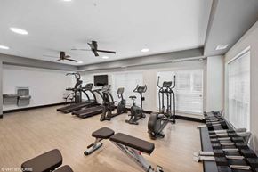 Minneapolis apartment for rent - A spacious gym with a variety of equipment including treadmills, stationary bikes, and weight machines.