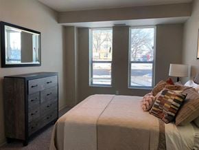 St. Paul apartment for rent - a bedroom with a bed and a dresser and three windows