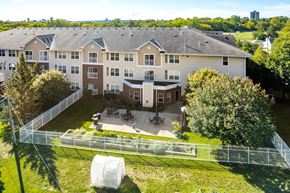 Saint Paul apartment for rent - A large apartment complex with a fenced in yard and a tree.