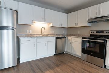 Woodbury apartment for rent - A kitchen with white cabinets and a stainless steel refrigerator.